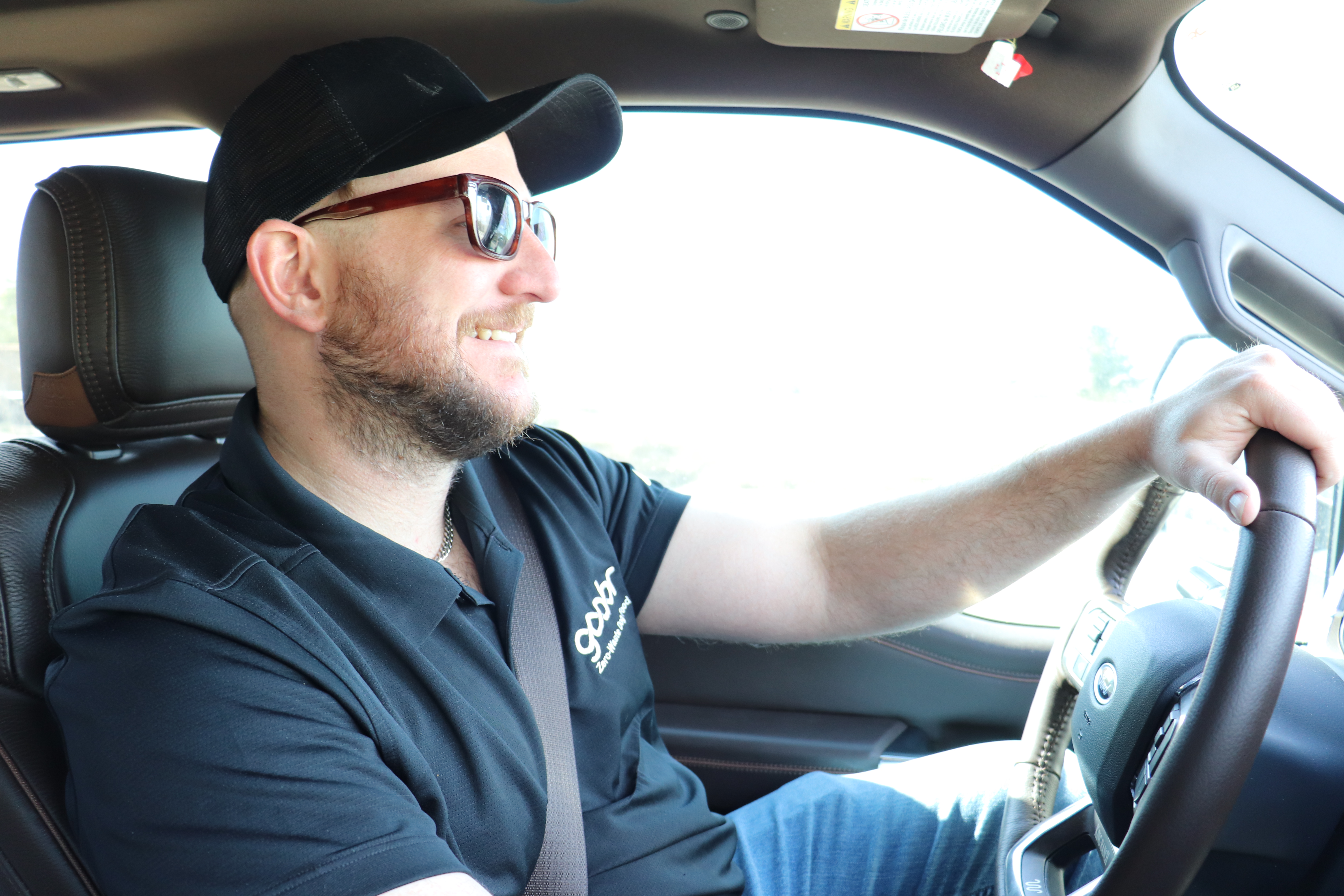 Tage, founder of Goobr, driving the Goobr delivery vehicle in a branded polo shirt